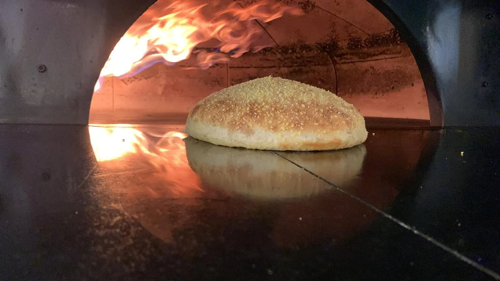 Il forno a legna acceso con l'impasto che cuoce
